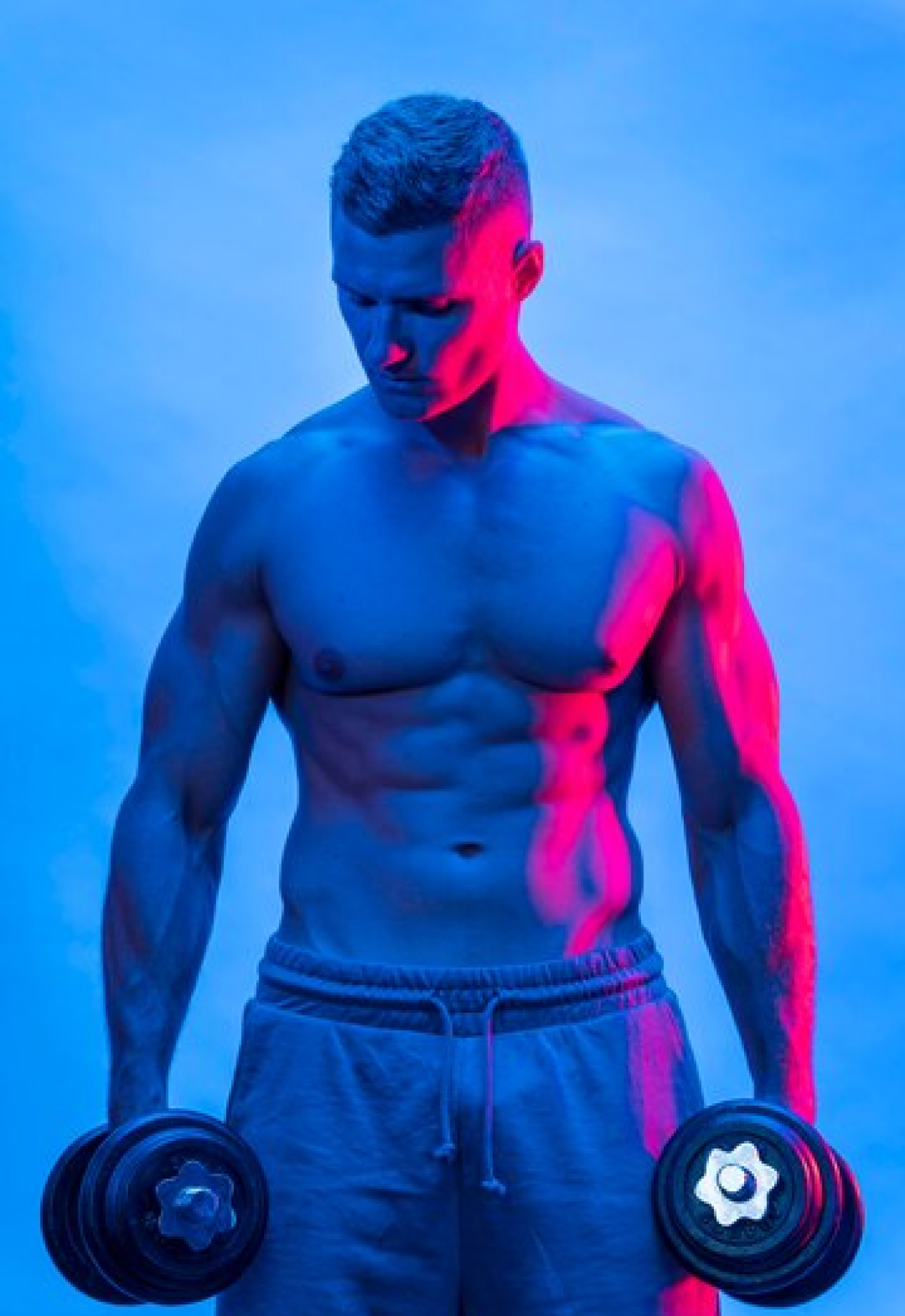 Спортивный мужчина занимается с гантелями